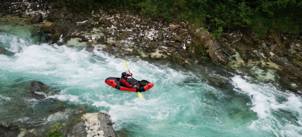 Packrafters peddelen op het turquoise water van de Soča rivier tijdens de European Packrafting Meet-up